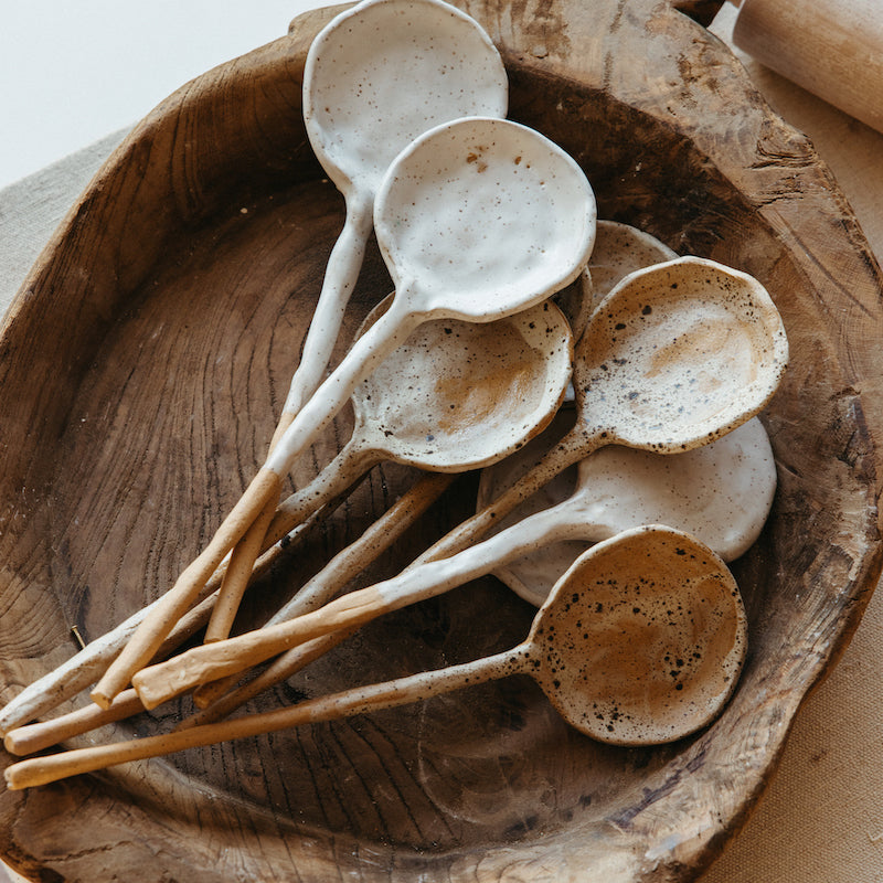 ceramic serving spoons in wooden bowl