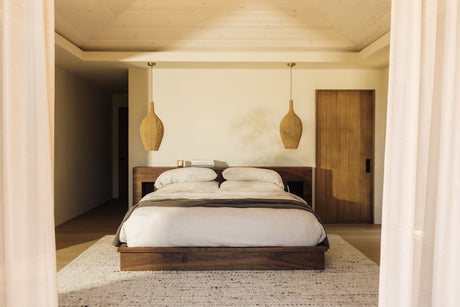 Sunwashed Linen Bedspread in Charcoal layered across a bed with white linens in a softly lit bedroom.