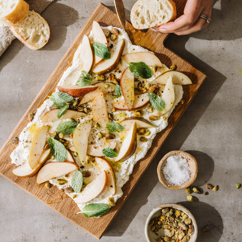 wooden serving board ricotta and pear board with pistachios honey mint and bread