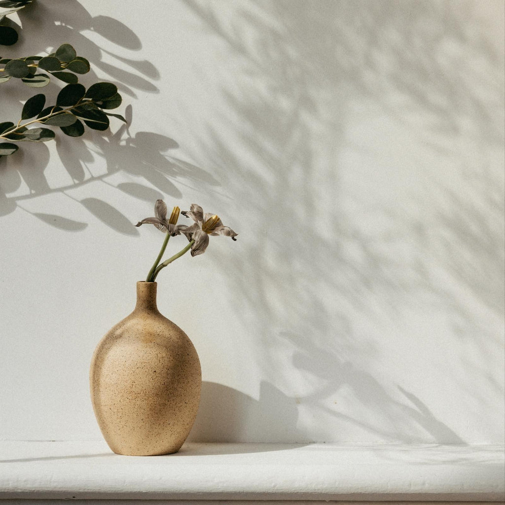 single stem vase with flowers on shelf