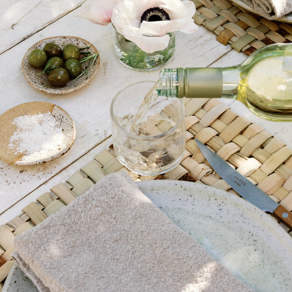 woven placemat with recycled glass white wine and Sabre cutlery flatware